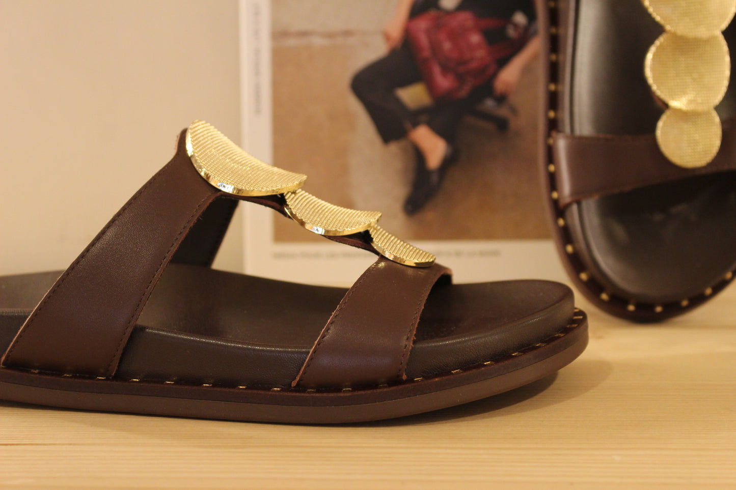 Mule ALPE en cuir de couleur chocolat. Habillage médaillon métallisé platine imprimé sur la bride salomé.