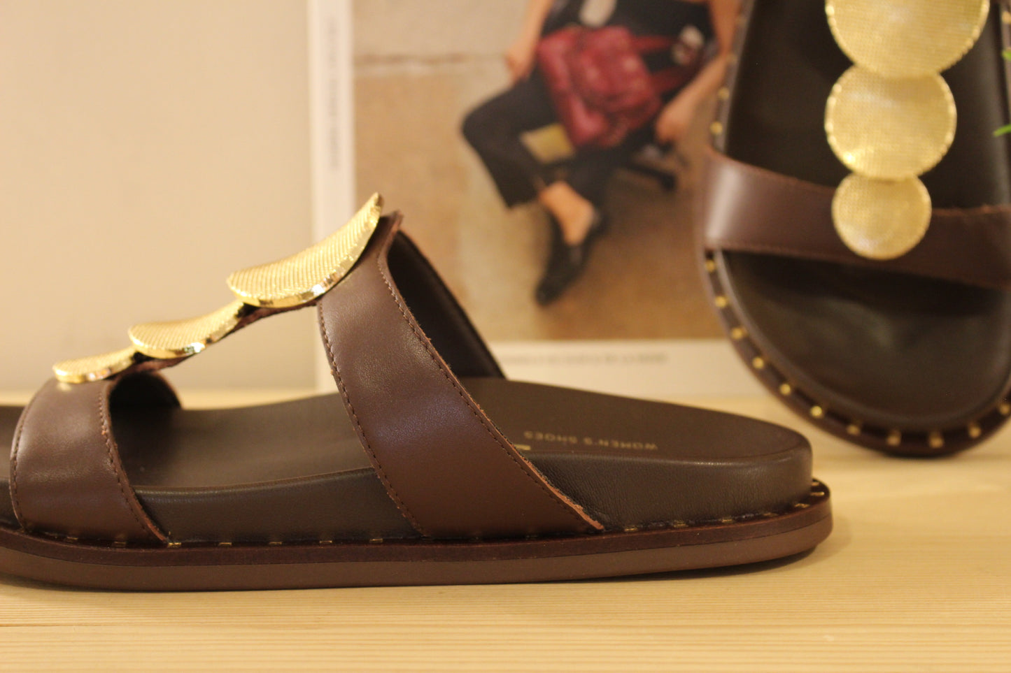Mule ALPE en cuir de couleur chocolat. Habillage médaillon métallisé platine imprimé sur la bride salomé.
