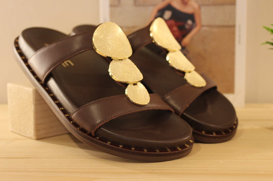 Mule ALPE en cuir de couleur chocolat. Habillage médaillon métallisé platine imprimé sur la bride salomé.
