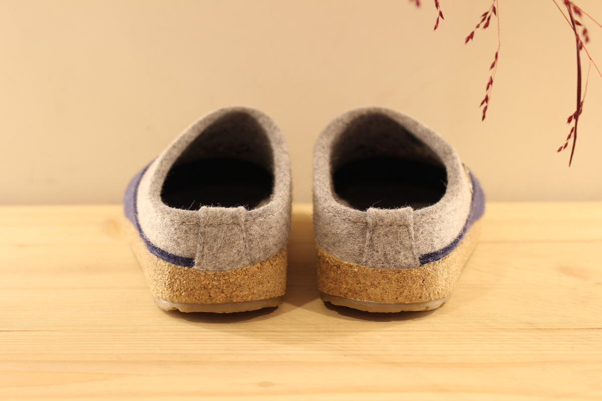 Chaussons HAFLINGER coupe sabot en pure laine de couleur gris anthracite et bleu chiné. Déco florale sur le coup de pied