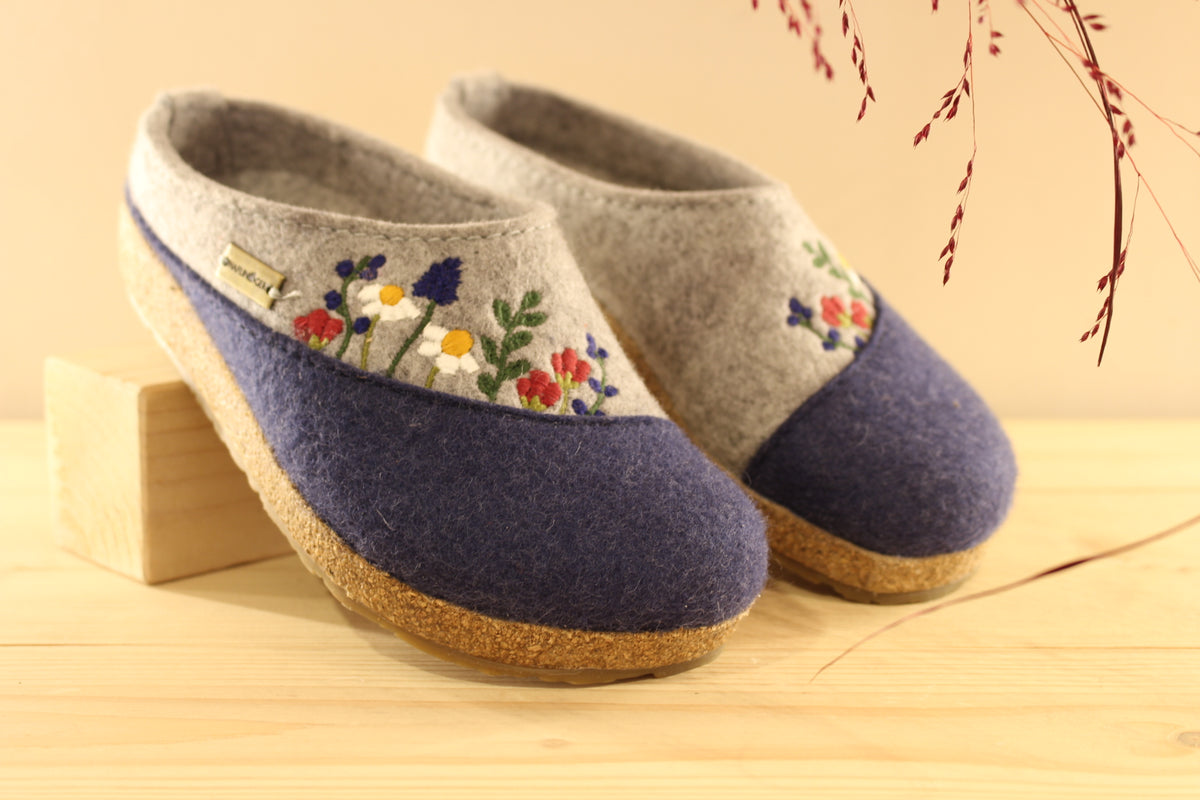 Chaussons HAFLINGER coupe sabot en pure laine de couleur gris anthracite et bleu chiné. Déco florale sur le coup de pied