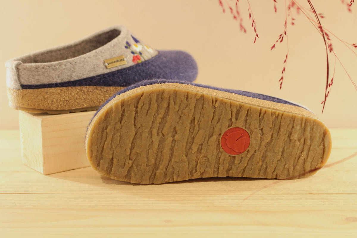 Chaussons HAFLINGER coupe sabot en pure laine de couleur gris anthracite et bleu chiné. Déco florale sur le coup de pied