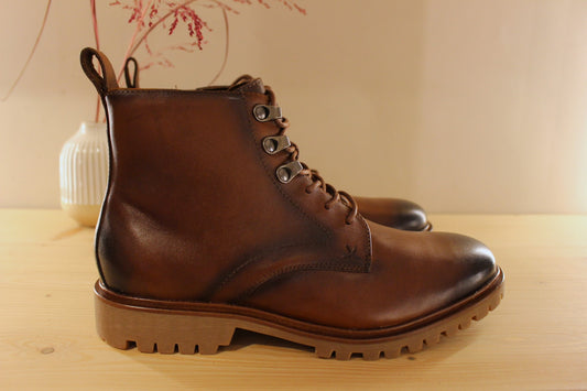 Bottines Lloyd en cuir de couleur cognac avec le bout bruni. Serrage lacets avec finition crochets. Zip du côté interne