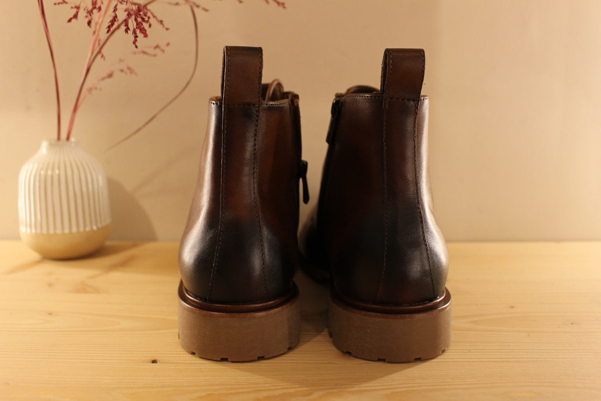 Bottines Lloyd en cuir de couleur cognac avec le bout bruni. Serrage lacets avec finition crochets. Zip du côté interne