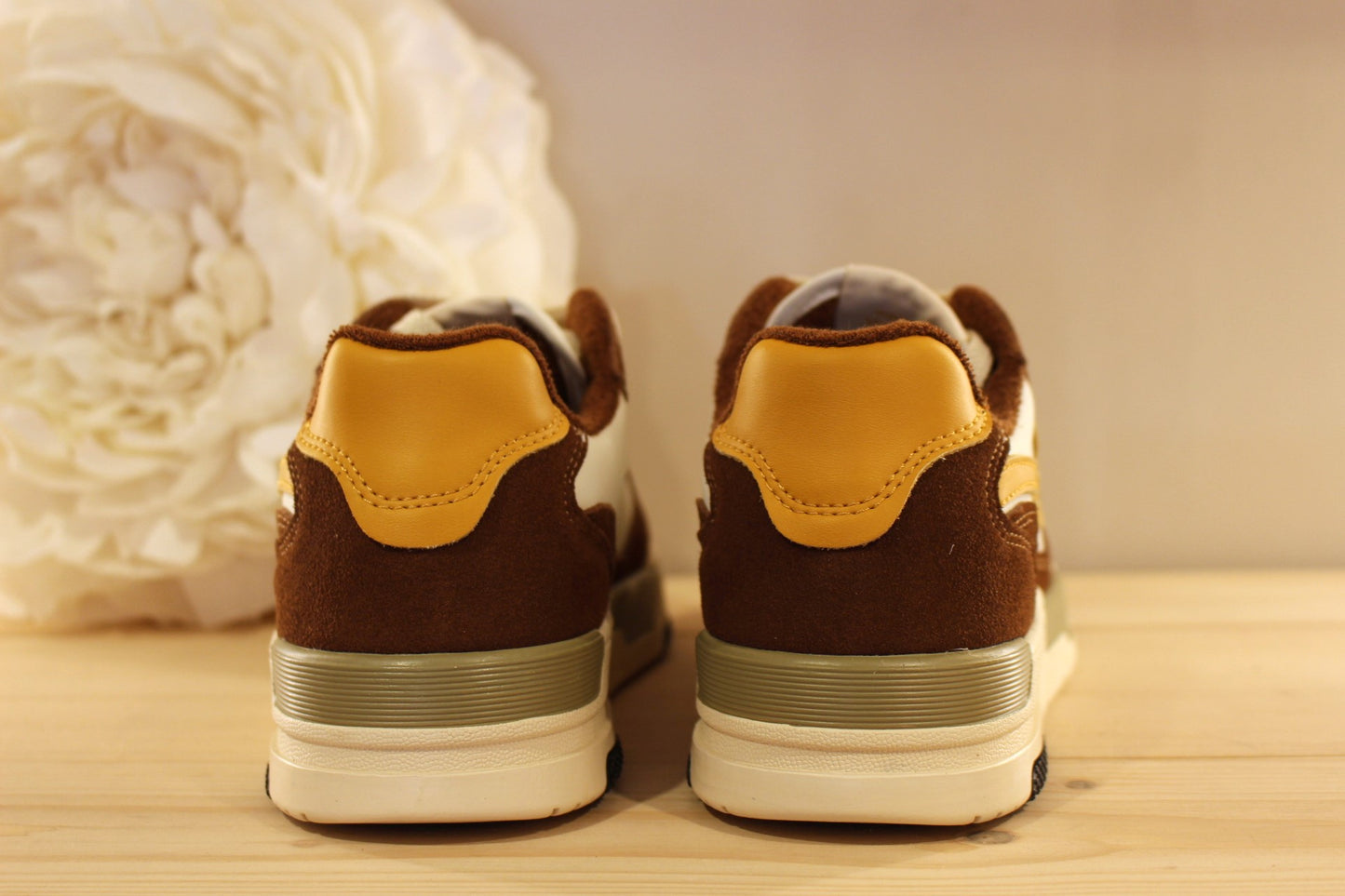  Sneakers homme en cuir lisse de couleur blanche et des touches de jaune, avec des parties en cuir velours marron sur l'avant et l'arrière du sneaker. 