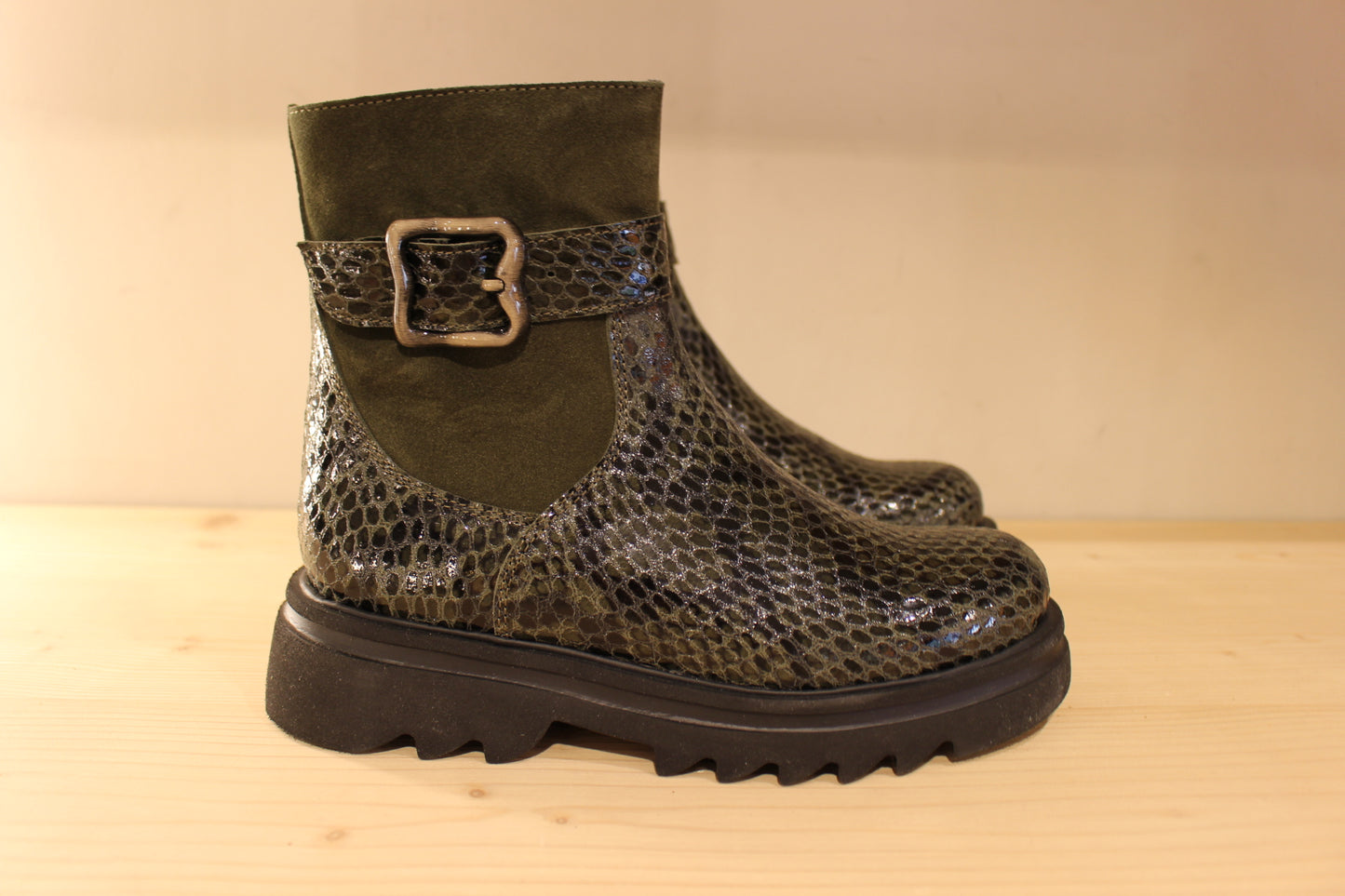 Bottines Casta en cuir imprimé python de couleur vert foncé. Finition velours sur le haut de la tige. Habillage ceinture. 