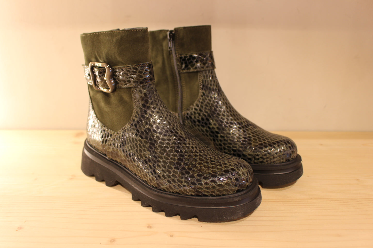 Bottines Casta en cuir imprimé python de couleur vert foncé. Finition velours sur le haut de la tige. Habillage ceinture. 