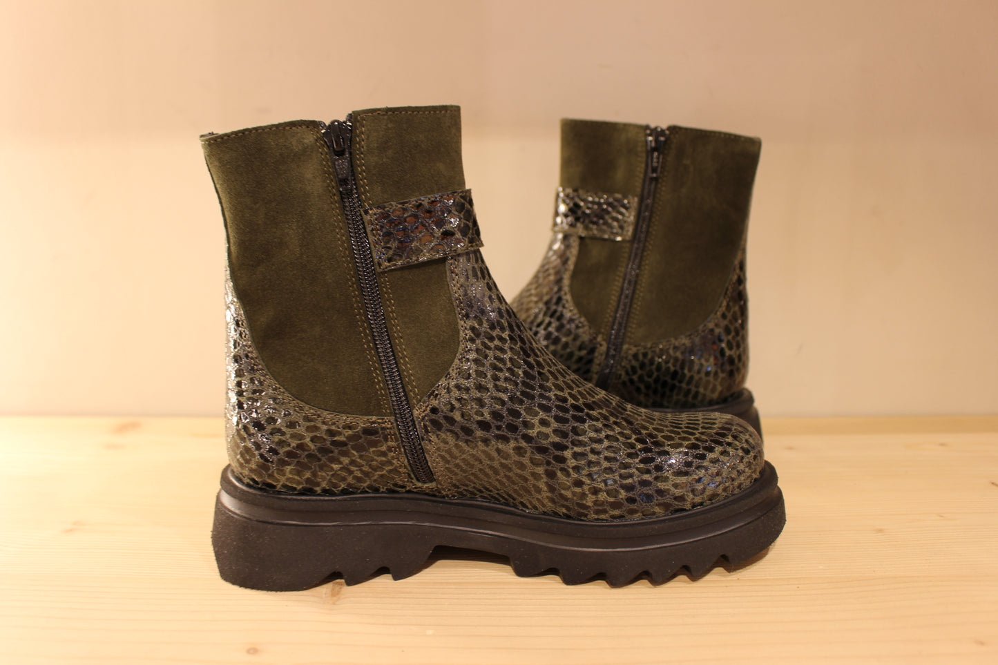 Bottines Casta en cuir imprimé python de couleur vert foncé. Finition velours sur le haut de la tige. Habillage ceinture. 