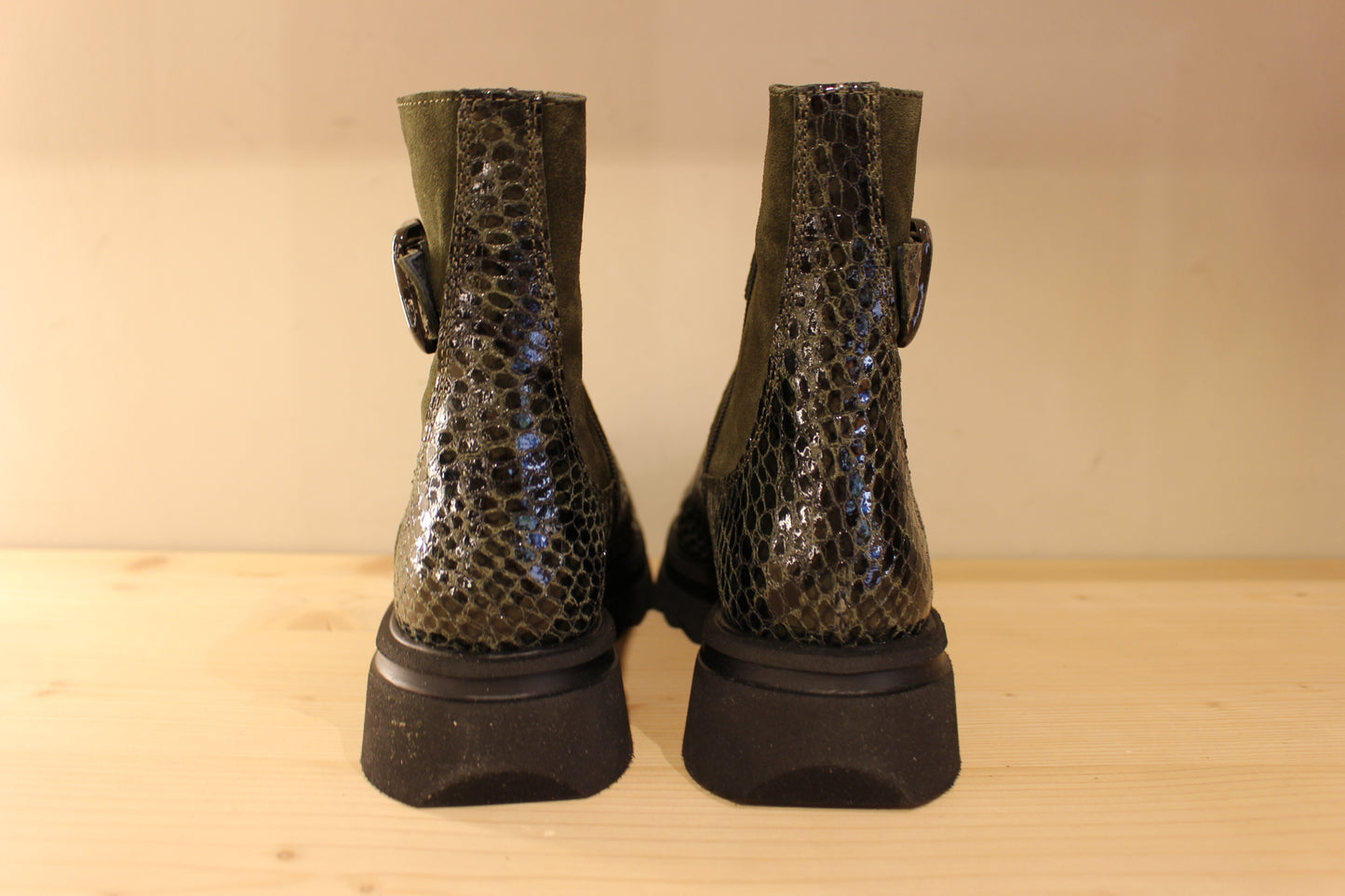 Bottines Casta en cuir imprimé python de couleur vert foncé. Finition velours sur le haut de la tige. Habillage ceinture. 