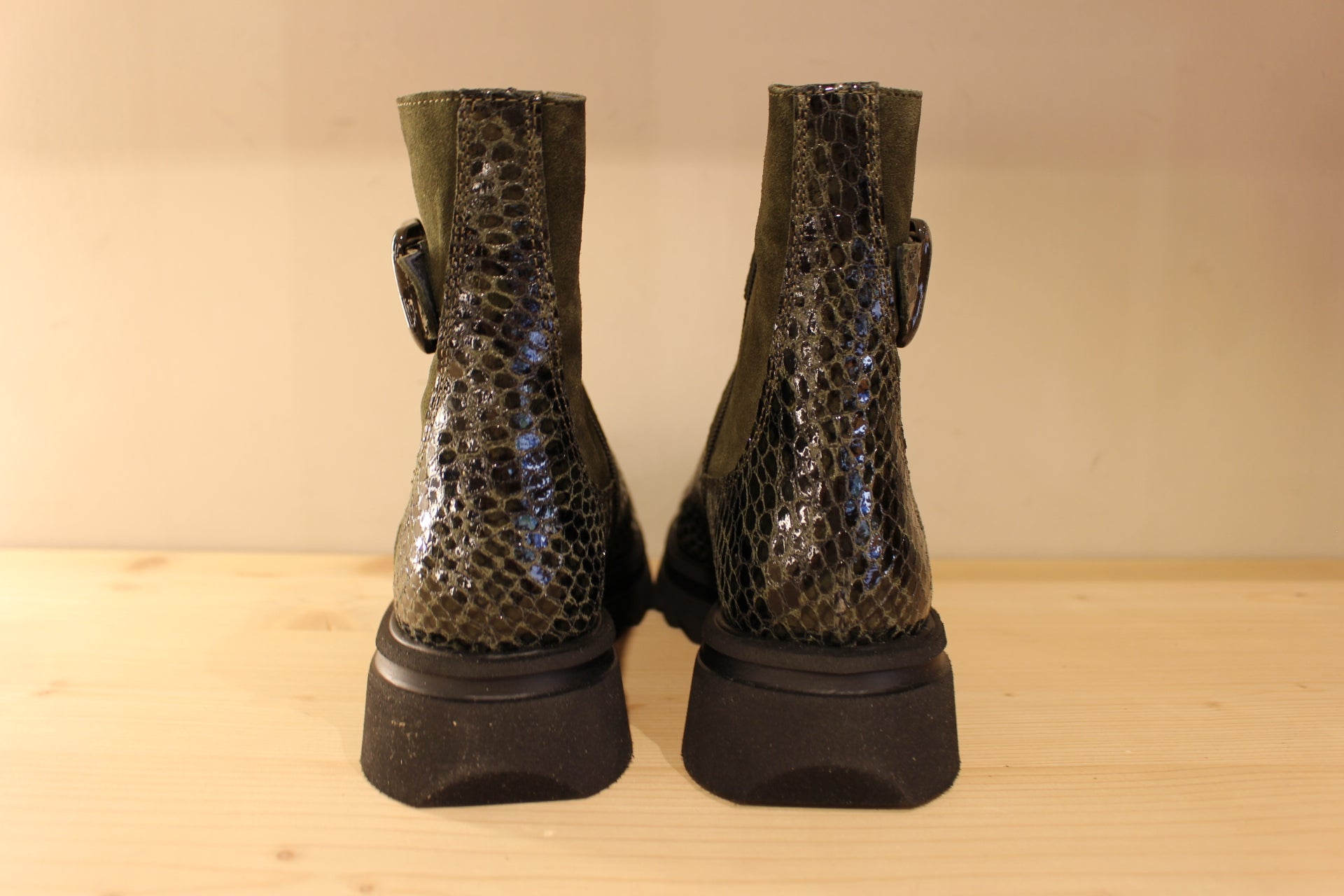 Bottines Casta en cuir imprimé python de couleur vert foncé. Finition velours sur le haut de la tige. Habillage ceinture. 