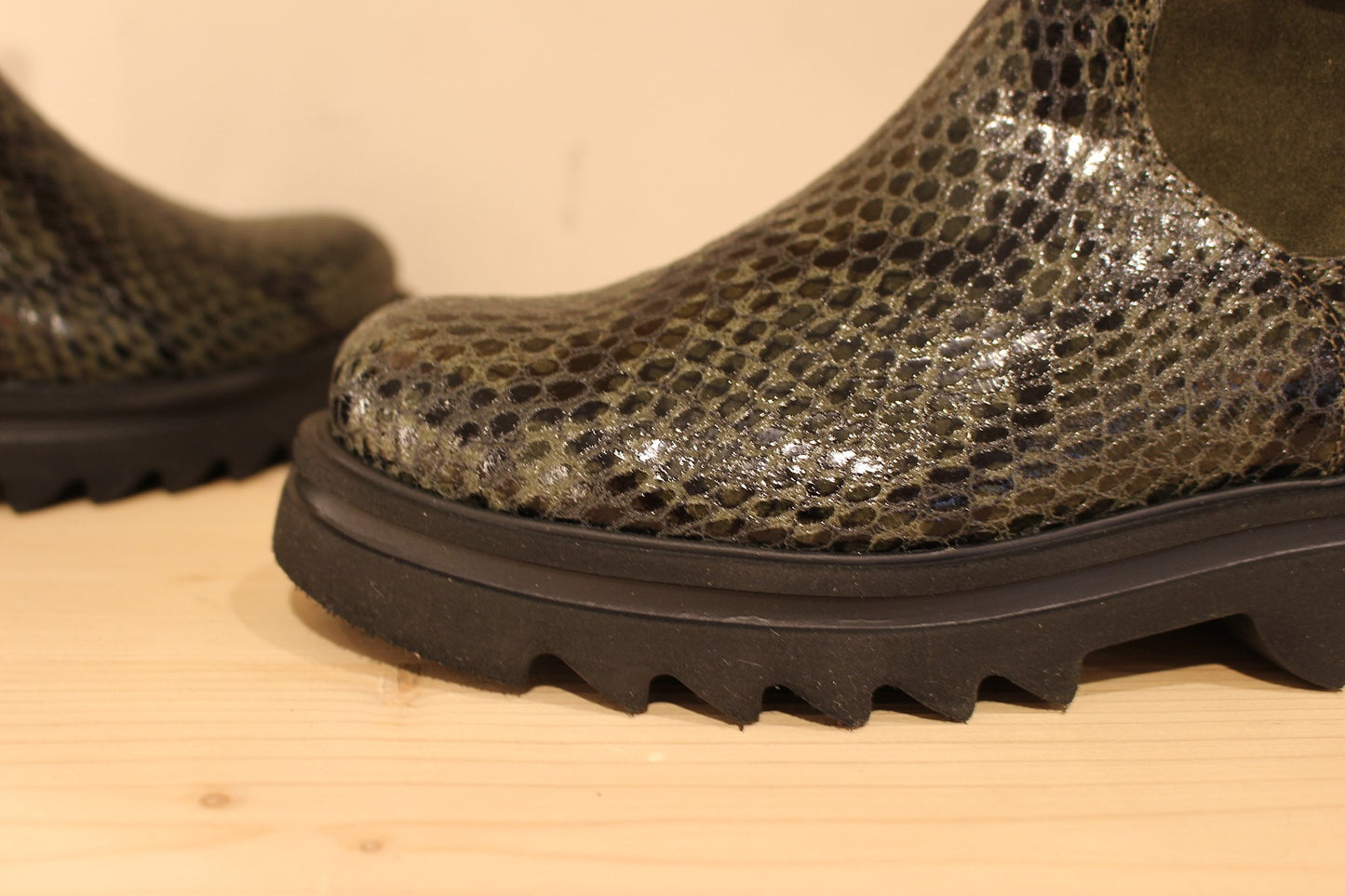Bottines Casta en cuir imprimé python de couleur vert foncé. Finition velours sur le haut de la tige. Habillage ceinture. 