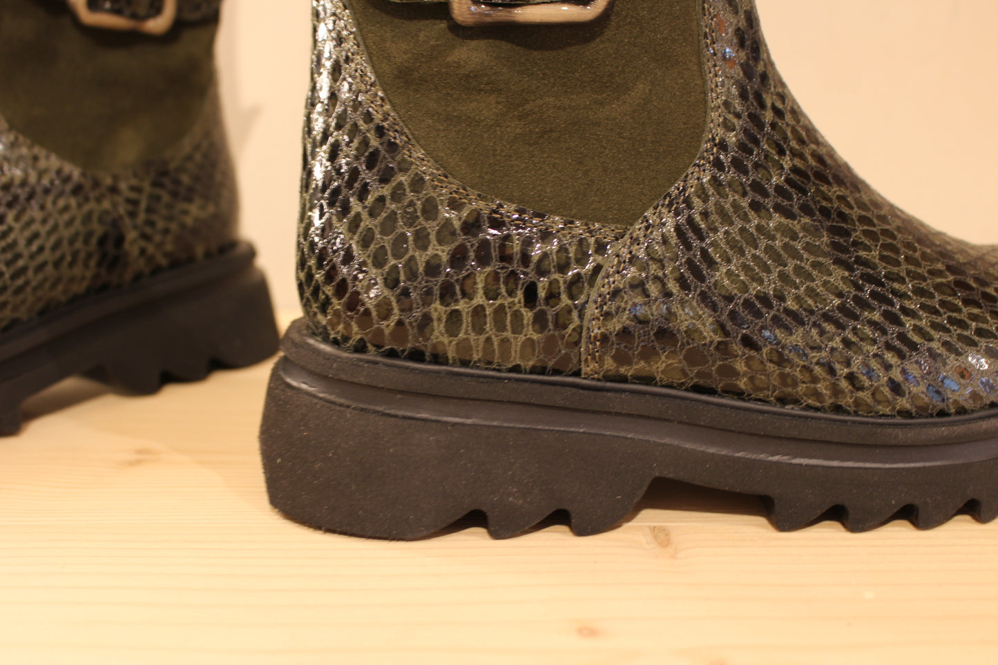Bottines Casta en cuir imprimé python de couleur vert foncé. Finition velours sur le haut de la tige. Habillage ceinture. 