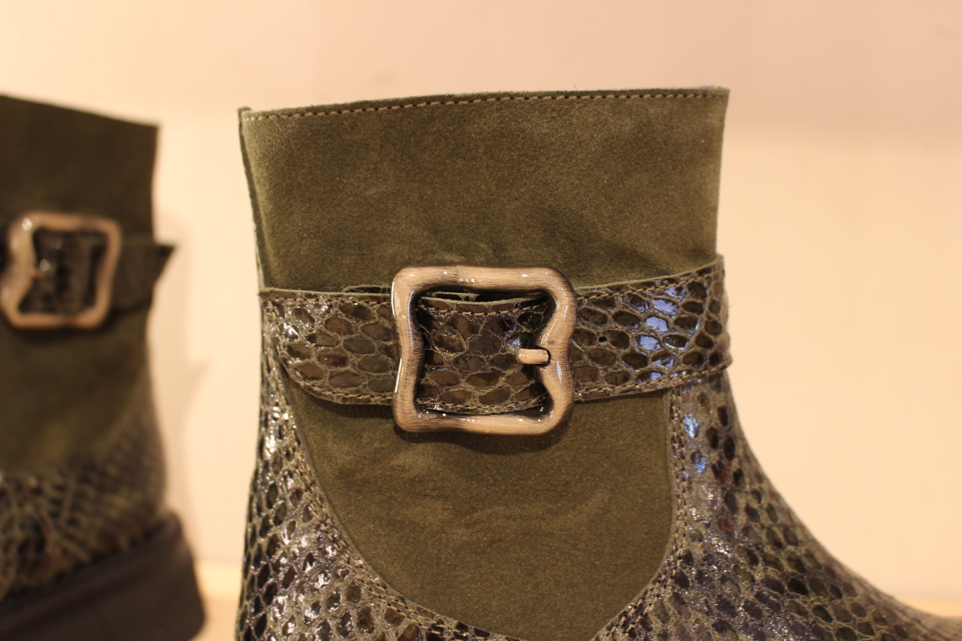 Bottines Casta en cuir imprimé python de couleur vert foncé. Finition velours sur le haut de la tige. Habillage ceinture. 