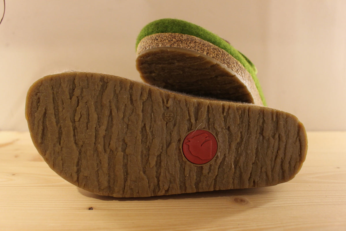  Chaussons HAFLINGER coupe sabot en pure laine de couleur vert ou beige. Déco de boutons colorés en laine sur le côté du coup de pied. Découpe asymétrique pour un bon maintien. 