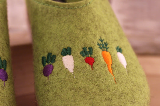 Chaussons coupe sabot en pur laine de couleur vert. Déco légumes colorés. Retour à l'arrière assez montant pour permettre un meilleur maintien à la marche.