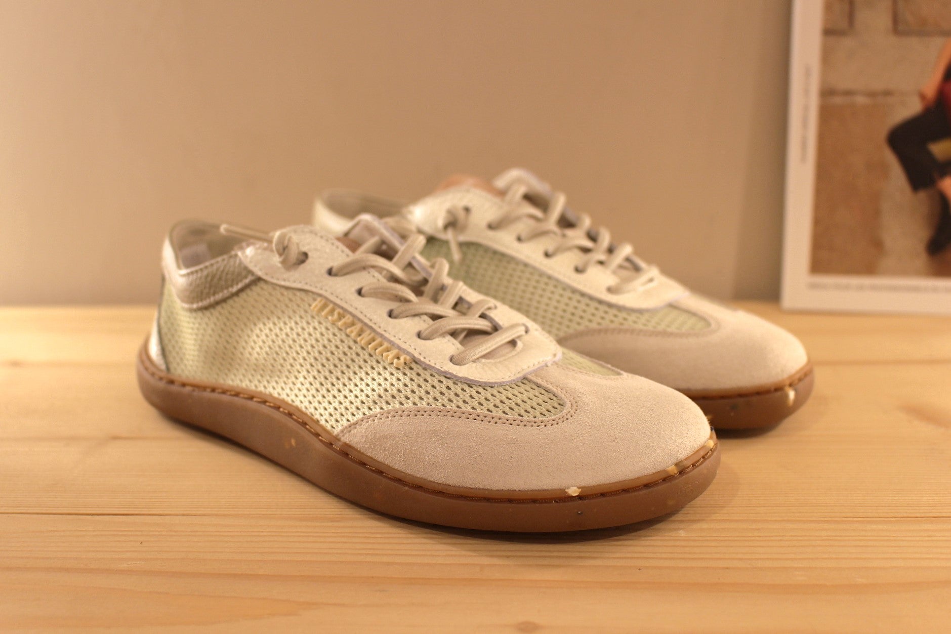 Basket HISPANITAS ligne barefoot en cuir sur un dégradé de gris et vert. Habillage résille sur les quartiers. 