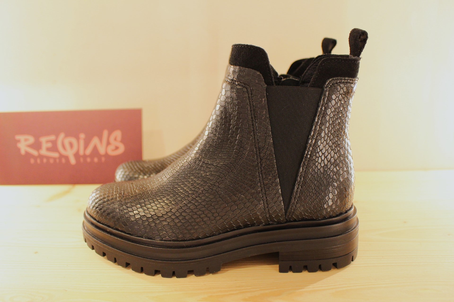 Boots REQINS en cuir imprimé python et velours de couleur noir. Chaussures doublées cuir. Zip du côté interne