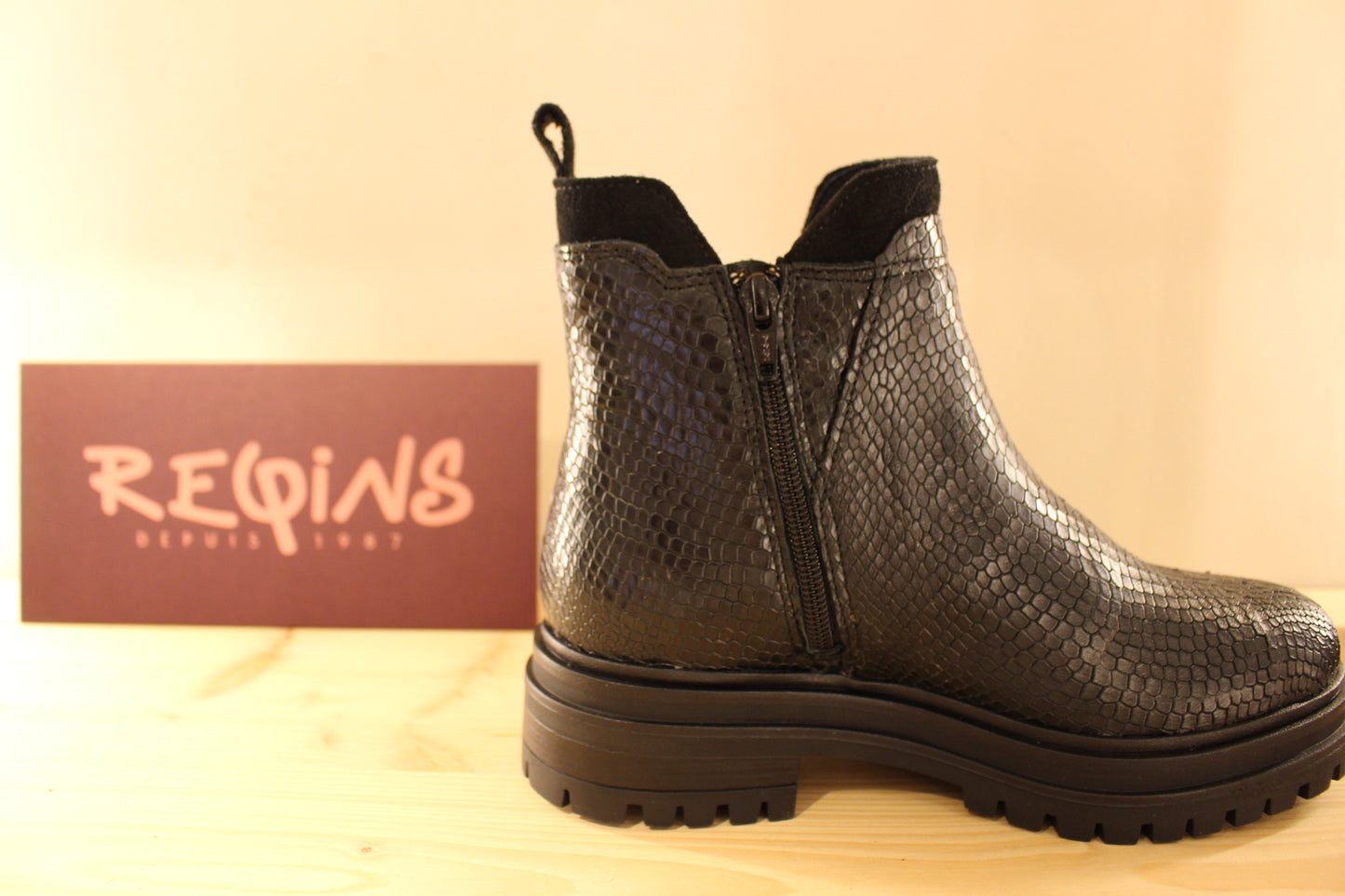 Boots REQINS en cuir imprimé python et velours de couleur noir. Chaussures doublées cuir. Zip du côté interne