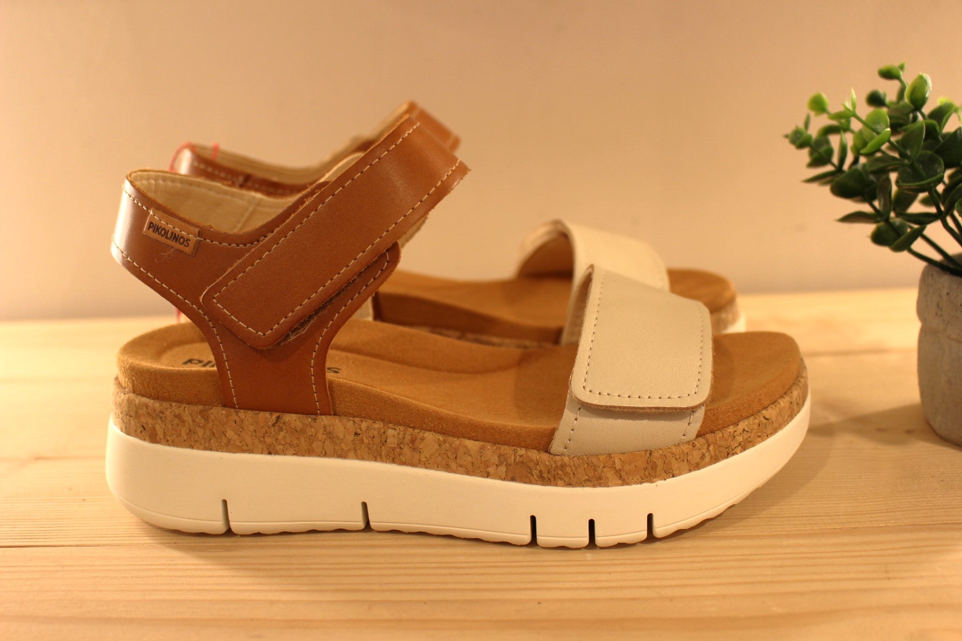 Sandales en cuir de couleur blanc cassé et camel. Serrage par deux scratchs, sur bride coup de pied et sur bride avant PIKOLINOS