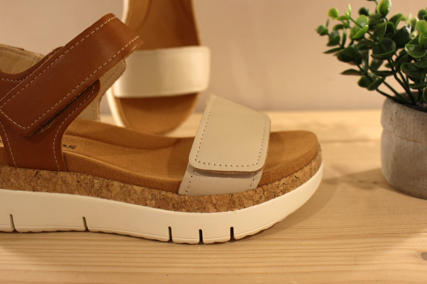 Sandales en cuir de couleur blanc cassé et camel. Serrage par deux scratchs, sur bride coup de pied et sur bride avant PIKOLINOS