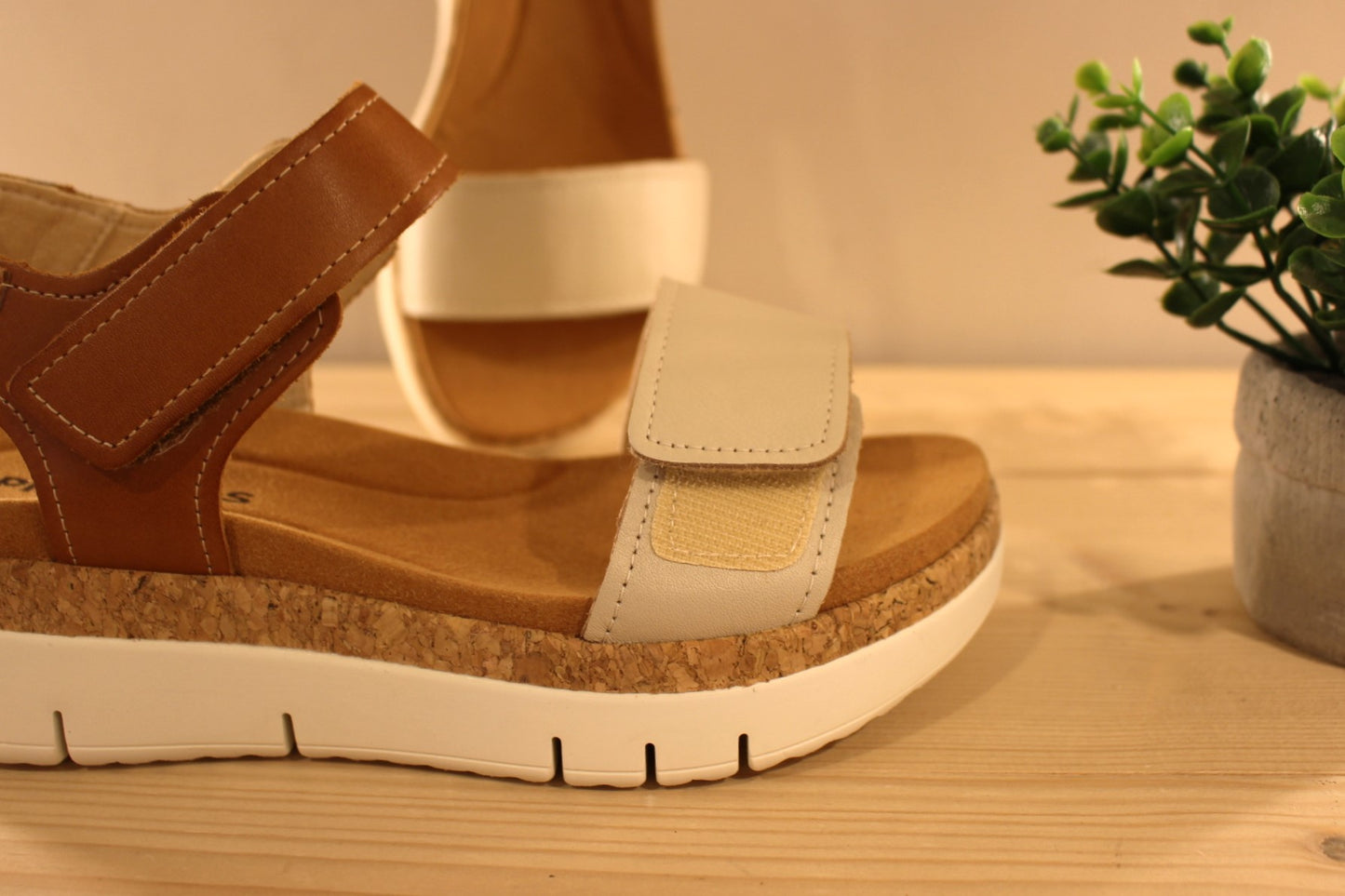 Sandales en cuir de couleur blanc cassé et camel. Serrage par deux scratchs, sur bride coup de pied et sur bride avant PIKOLINOS