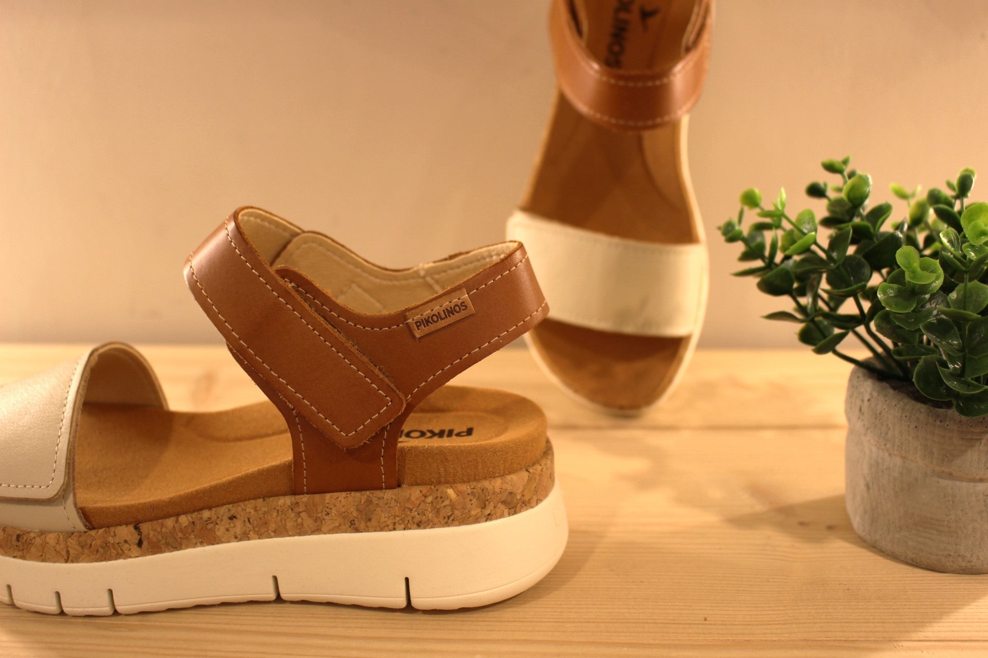 Sandales en cuir de couleur blanc cassé et camel. Serrage par deux scratchs, sur bride coup de pied et sur bride avant PIKOLINOS