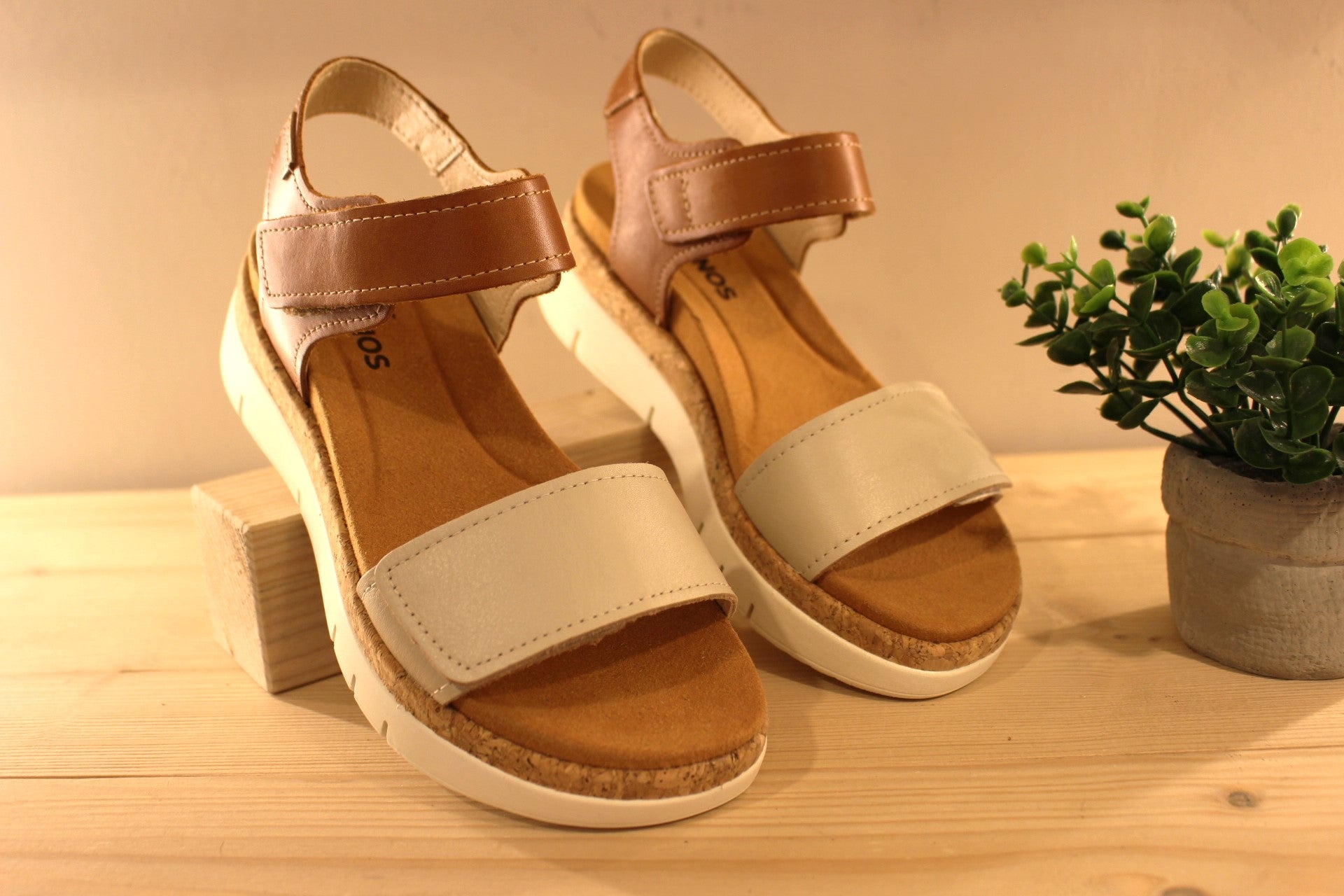 Sandales en cuir de couleur blanc cassé et camel. Serrage par deux scratchs, sur bride coup de pied et sur bride avant PIKOLINOS